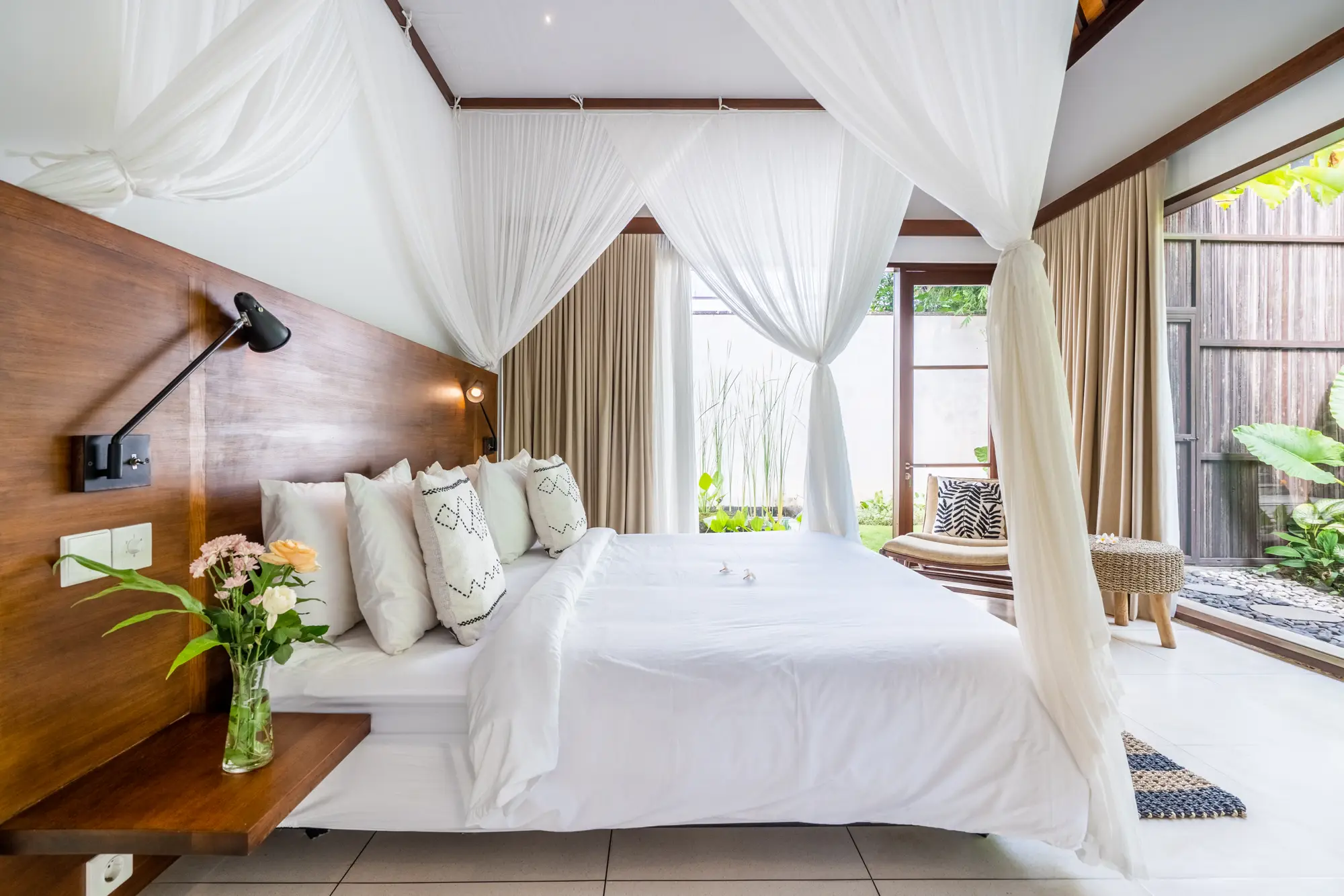 A bedroom suite with a four-poster bed and white netting
