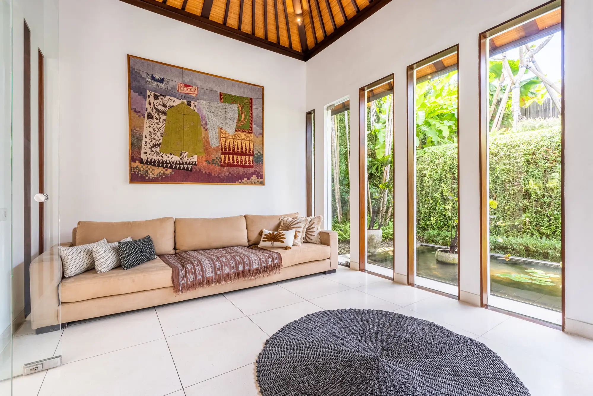 A bedroom suite with a sitting area and a painting