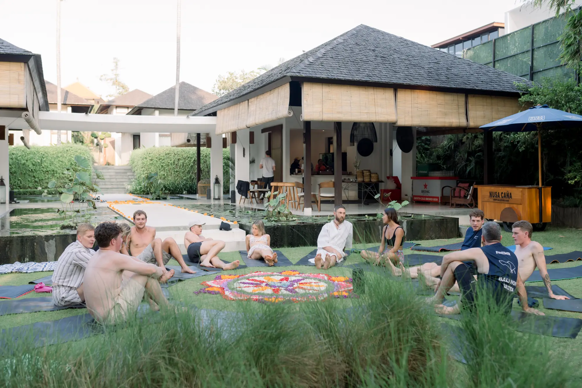 Guests sitting on the lawn around a flower mandala