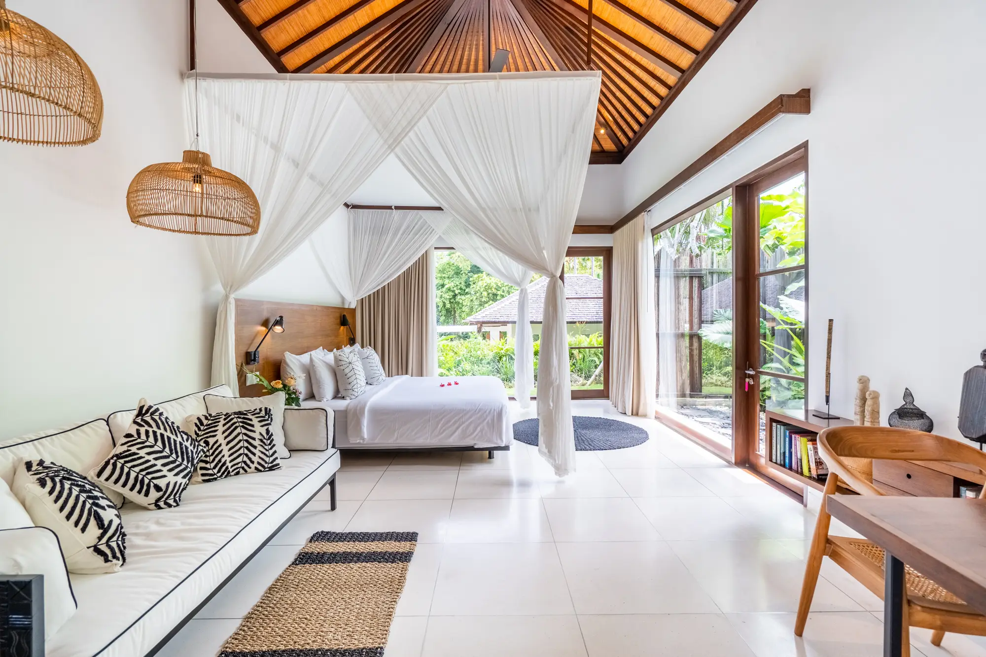 A bedroom suite with a four-poster bed, mosquito net and garden windows