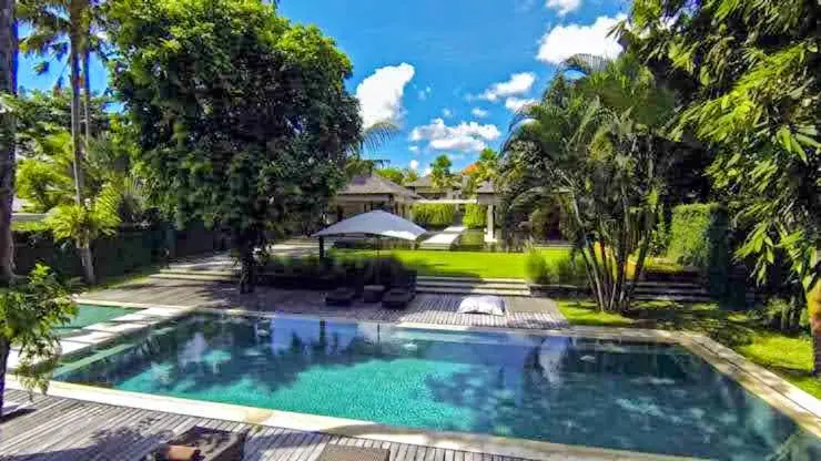 The swimming pool among palms and tropical trees