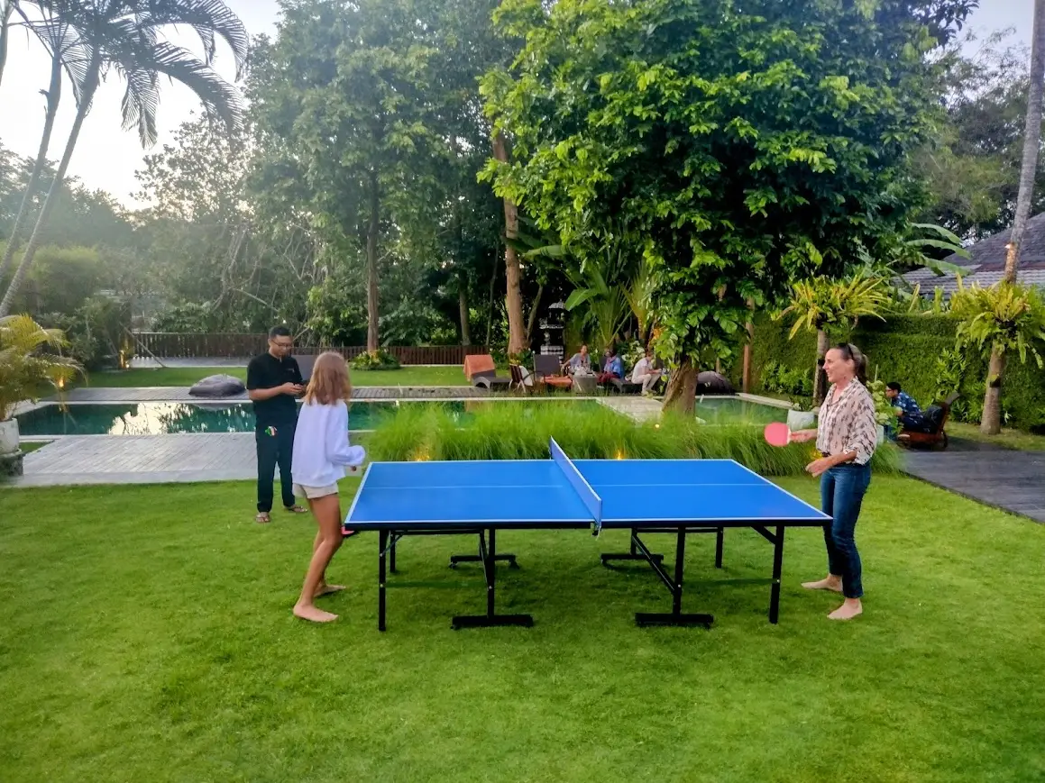 A game of table tennis on the lawn beside the pool