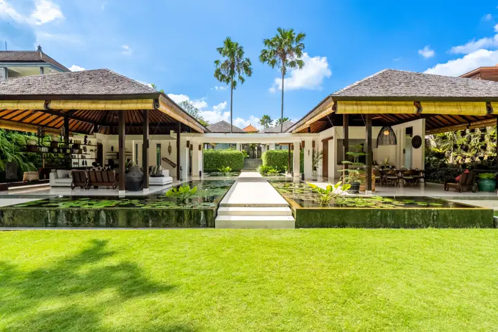 The lawn, lotus ponds and open pavilions of Villa Bengawan under a blue sky