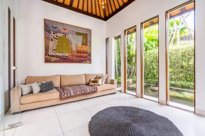 A bedroom suite with a sitting area and a painting