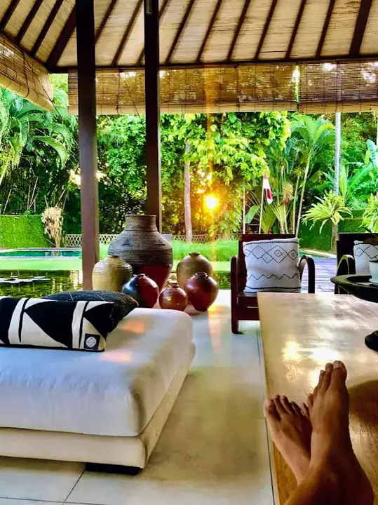 Feet up on a day bed in the open living pavilion, looking at the garden