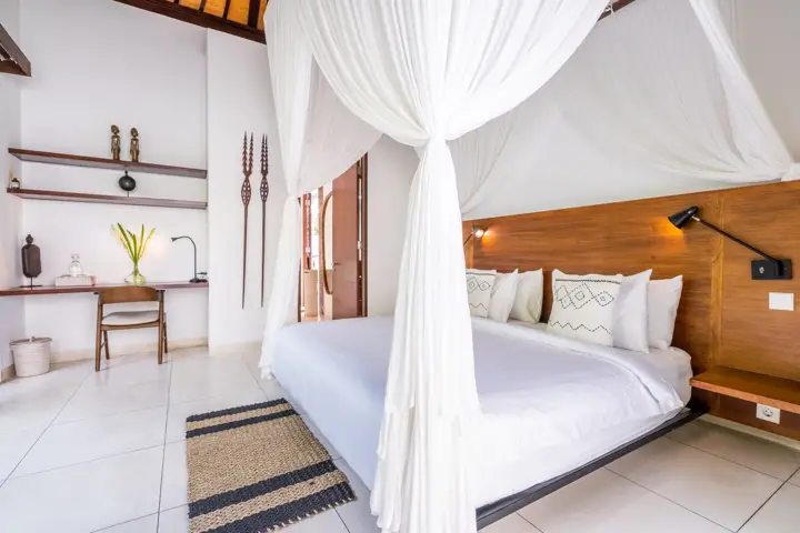 A bedroom suite with a four-poster bed and a writing desk