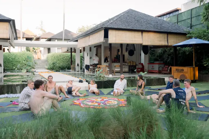 Guests sitting on the lawn around a flower mandala