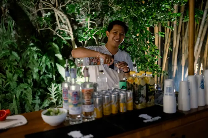 A bartender preparing drinks at an outdoor bar