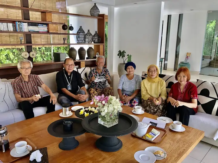 Three generations of a family having coffee in the living room